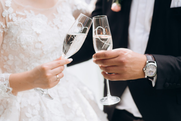 groom-with-bride-are-knocking-glasses-with-champagne_8353-10453